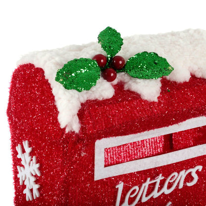 Close up of glittering holly leaves and berries on a letters to Santa post box outdoor Christmas decoration