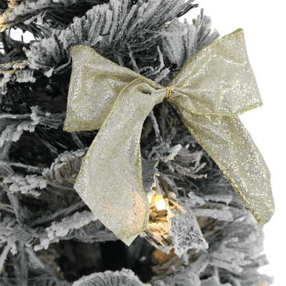 gold glitter bow on flocked christmas tree
