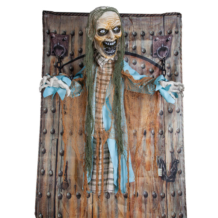 Zombie figure chained to a prison door with studs fr Halloween parties