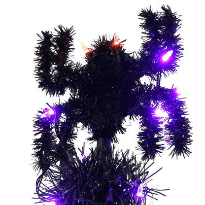 close up shot of tinsel spider at top of tree with purple and orange lights