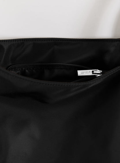 Lähikuva mustasta Nylon Weekend Bagista, jossa on hopeisella aim'n-logolla varustettu sisätaskun vetoketju.