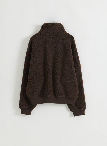 Suklaanruskea pilefleece-puolivetoketjullinen takki kuvattuna takaa flat lay -asetelmassa
