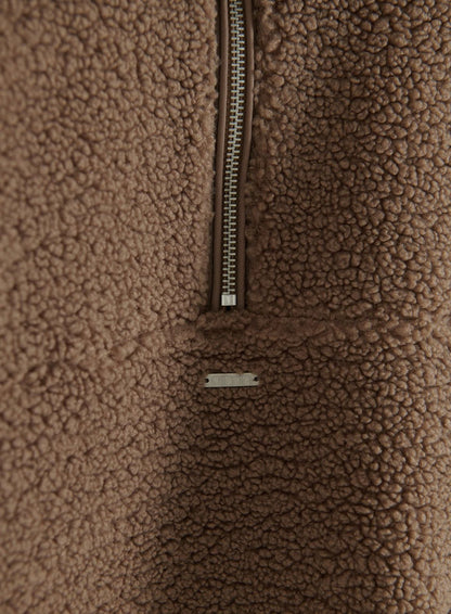 Lähikuva hazelnut pile half-zip -fleecepaidasta, jossa näkyy vetoketju ja aim'n-metallilogolappu