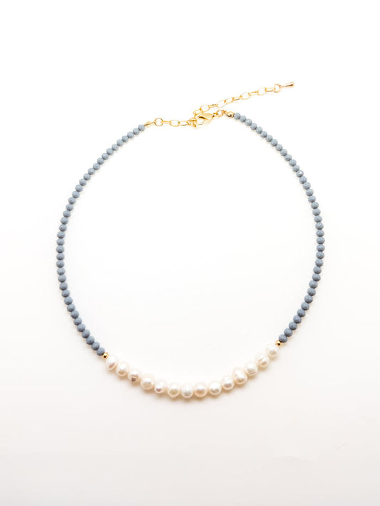 A dark blue beaded necklace with elegant white pearls, featuring an adjustable gold-colored chain.