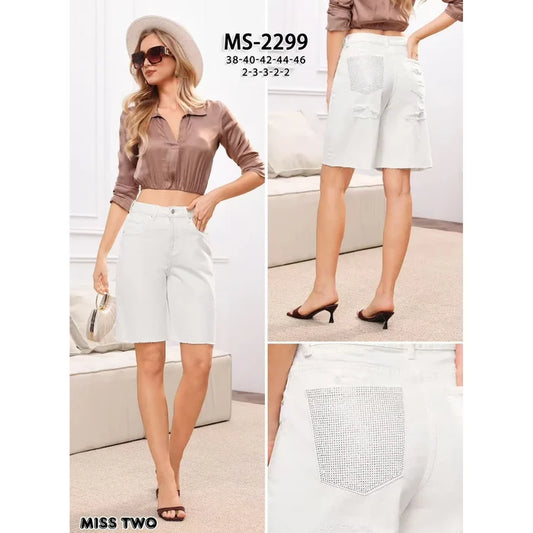 Ivory stretch denim Bermuda shorts featuring crystal embellished back pockets, subtle distressed patches, and raw hems.