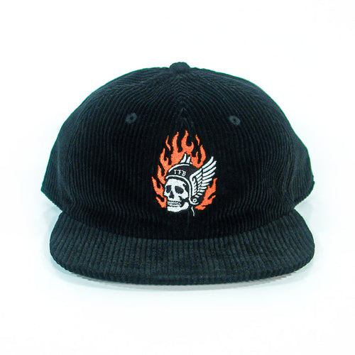 A black corduroy baseball cap from The Front Bottoms, featuring a flaming skull in a winged helmet and "1776" embroidered on the front, shown head-on against a white background. Ideal for fans of bold embroidered hats.
