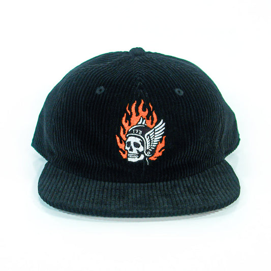 A black corduroy baseball cap from The Front Bottoms, featuring a flaming skull in a winged helmet and "1776" embroidered on the front, shown head-on against a white background. Ideal for fans of bold embroidered hats.
