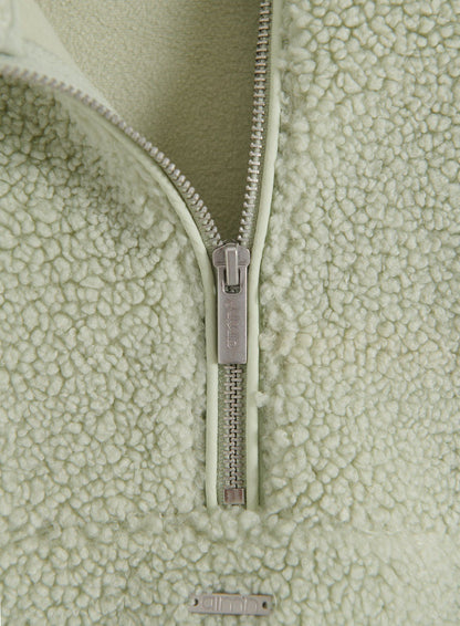 Lähikuva Pistachio Pile Half Zip -takin vetoketjusta ja pehmeästä nukkaisesta fleecemateriaalista