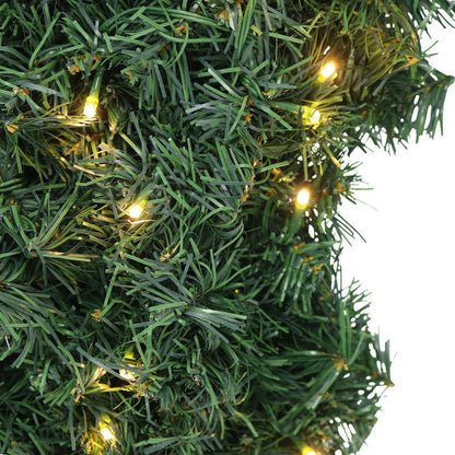 Green artificial Christmas tree with small lights on a white background