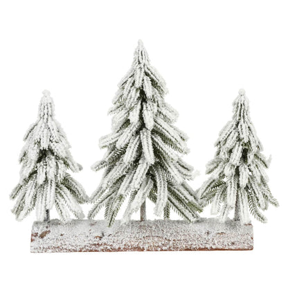 Set of three snow-covered pine trees on a wooden base against a white background