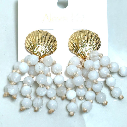 White beaded earrings featuring a golden shell-shaped detail for a coastal-inspired boutique jewelry look.
